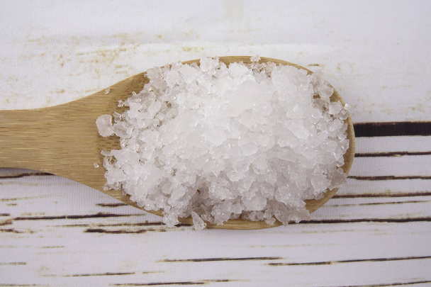 Sel marin dans une cuillère en bois. Aussi appelé sel de laurier ou sel solaire, est utilisé dans la cuisine et les cosmétiques. Cristaux de grains bruts du minéral
. - Photo, image