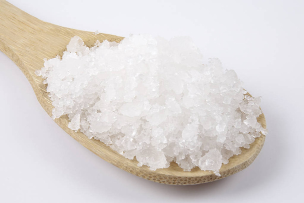 Tengeri só egy fakanállal. Más néven bay só vagy solar só, használják a főzés és kozmetikumok. Durva szemcsés kristályok, ásványi. - Fotó, kép