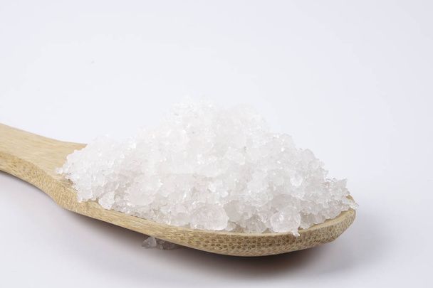 Морська сіль в дерев'яній ложці. Також називається солоною або сонячною сіллю, використовується в кулінарії та косметиці. Грубозернисті кристали мінералу
. - Фото, зображення