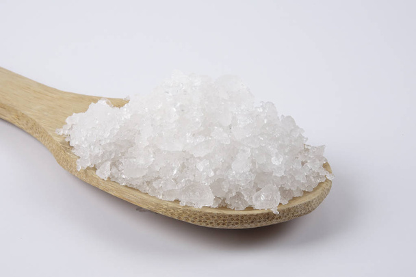 Bir tahta kaşık içinde deniz tuzu. Defne tuz olarak da adlandırılır veya güneş tuz, yemek ve kozmetik kullanılır. Kaba taneli mineral kristalleri. - Fotoğraf, Görsel