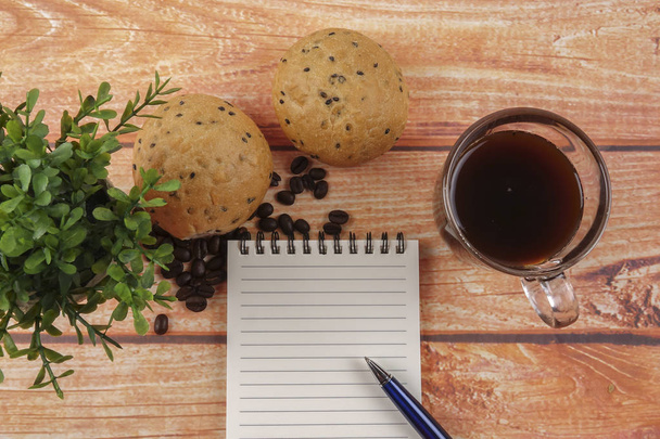 Morning breakfast concept with coffee,bun, post it notes on wooden background. - Photo, Image