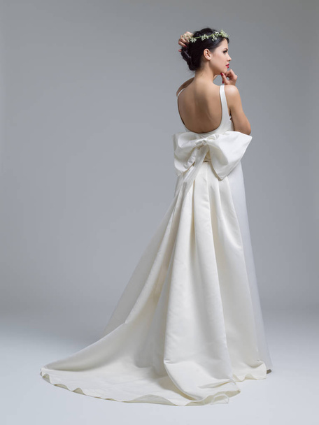 Rear view of a beautiful young woman in a wedding dress - Фото, зображення
