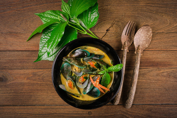Delicious asian style curry mussels with red pepper, green onion, and coriander in a coconut broth. - Fotoğraf, Görsel