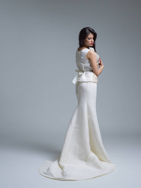 Rear view of a beautiful young woman in a wedding dress - Foto, Imagen