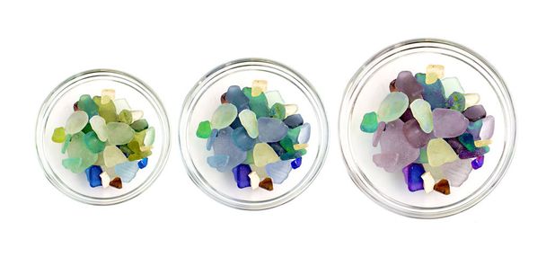 seixos coloridos em uma taça de vidro no fundo branco
 - Foto, Imagem