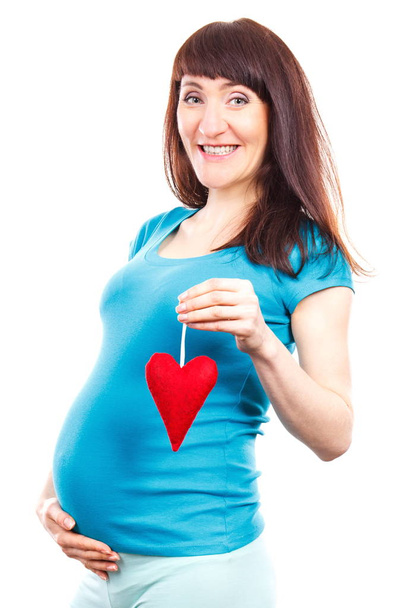 Happy smiling pregnant woman with red heart, symbol of new life and expecting for newborn - Foto, Imagem