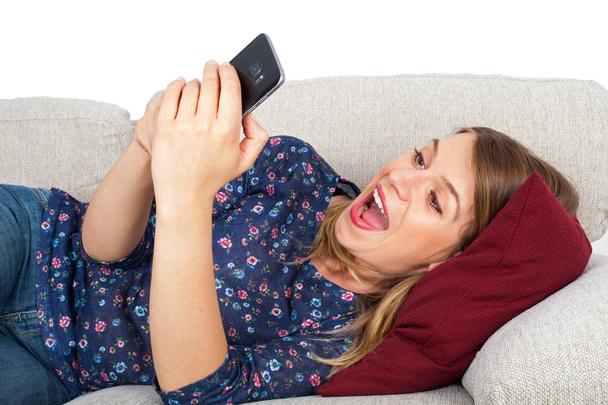 Woman having a video chat, lying on couch - Zdjęcie, obraz