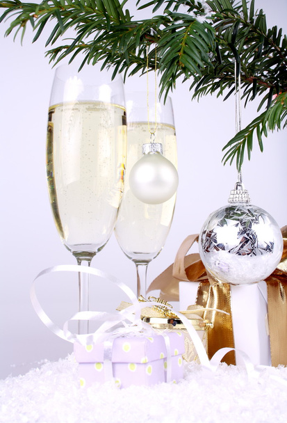 Bola de plata de Año Nuevo en una rama de árbol de Navidad con regalos y champán
 - Foto, Imagen