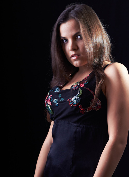 attraktive junge Frau in schwarzer Bluse auf schwarzem Hintergrund - Foto, Bild