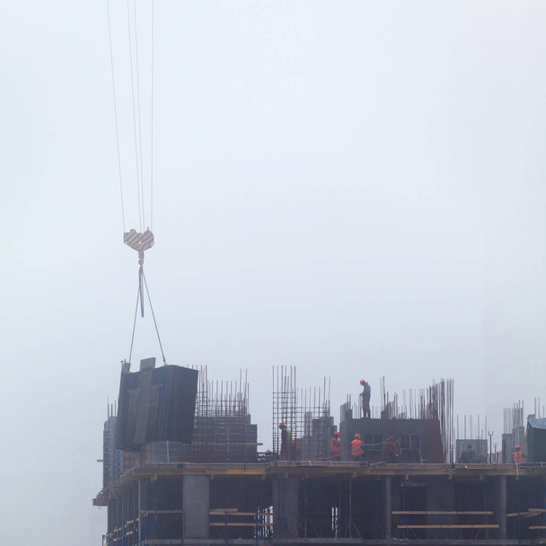 Un nuevo edificio residencial en construcción en la niebla de la mañana
. - Foto, Imagen