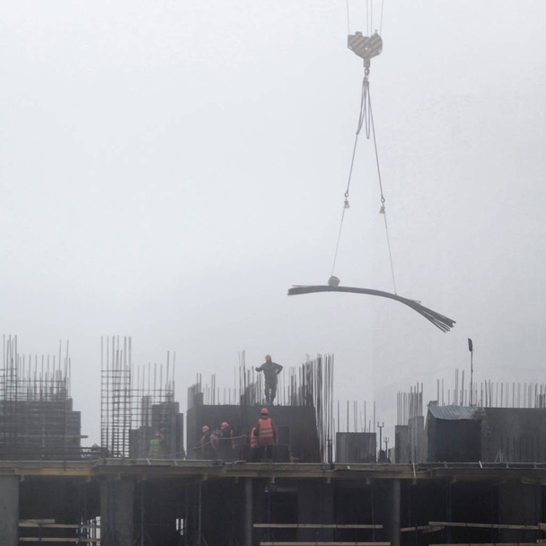 Een nieuwe residentieel gebouw in aanbouw in de ochtend mist. - Foto, afbeelding