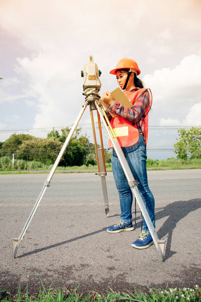 Женщина-геодезист или инженер, принимающая меры на шоссе
. - Фото, изображение