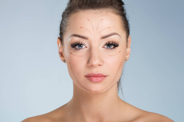 Молода красива жінка з хірургічними маркерами на обличчі
 - Фото, зображення