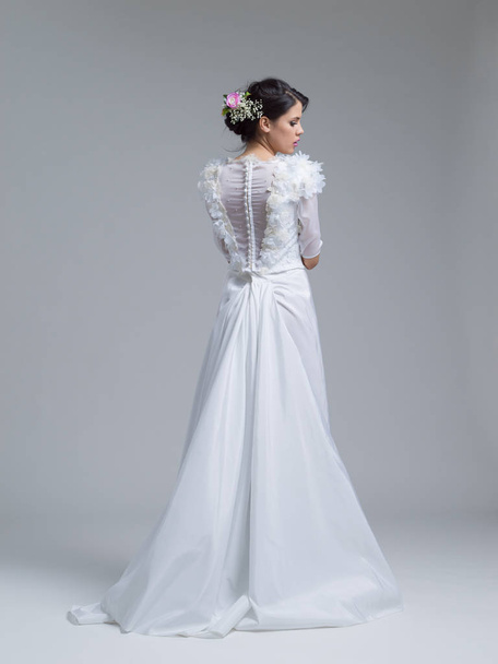 Rear view of a beautiful young woman in a wedding dress - Foto, imagen