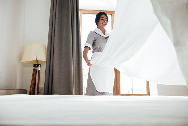 Hotel maid changing bed sheet - Photo, Image