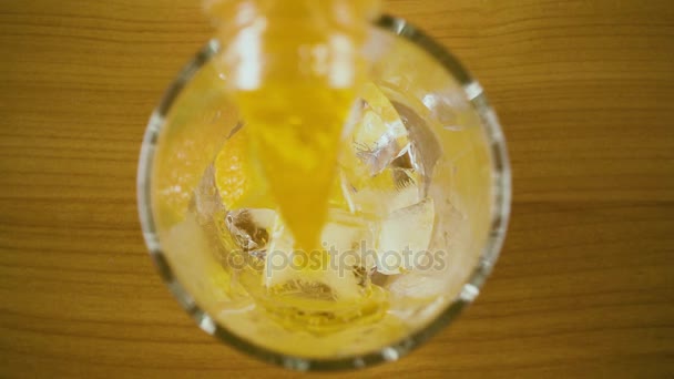 Langzame mo. oranje drinken in een glas te gieten bovenaanzicht - Video