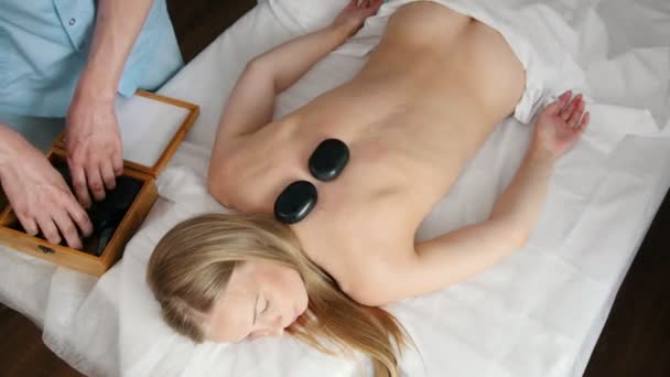 Piedras en la espalda de una chica en una sala de fisioterapia
 - Imágenes, Vídeo