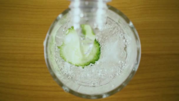 Slow-motion. Vul een glas met komkommer water volledig bovenaanzicht - Video