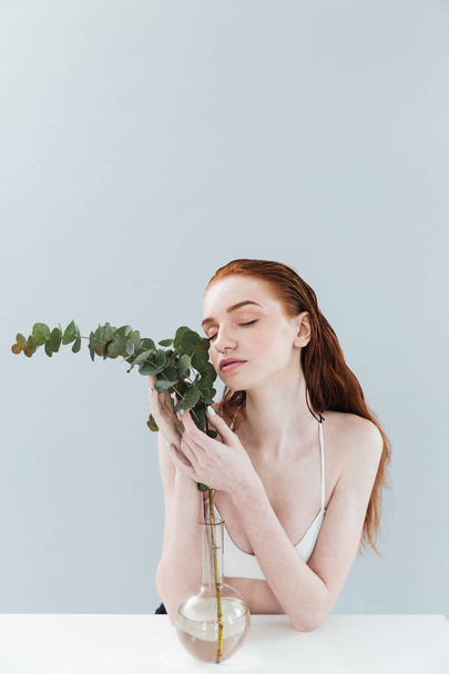 Fashion portrait of a beautiful young redheaded girl sitting - Foto, afbeelding