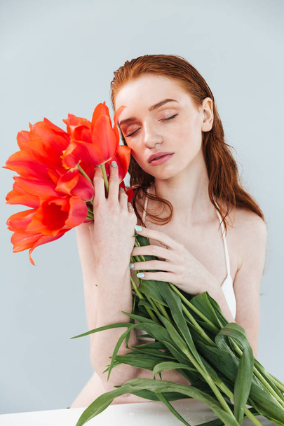 Portrait of a young beautiful woman holding tulips bouquet - Fotoğraf, Görsel