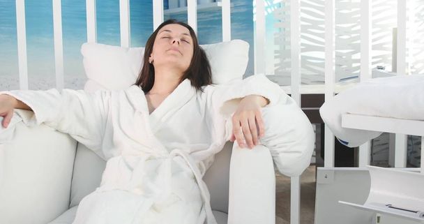 Beautiful woman relaxing in a bathrobe in spa salon - Фото, зображення