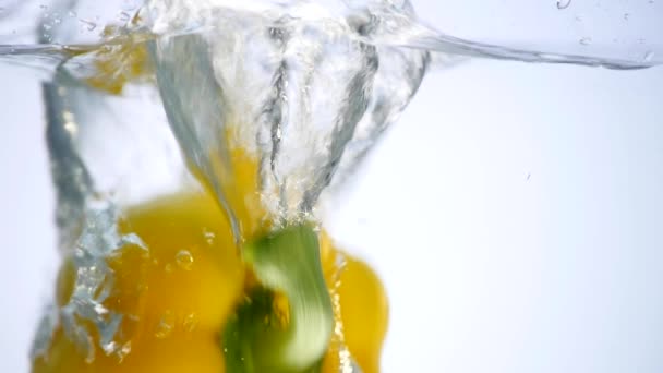 Peppers falling in water on white background - Video, Çekim
