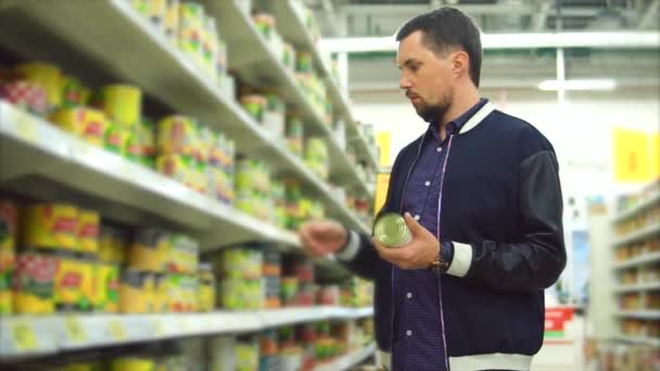 Ο άνθρωπος επιλέγοντας κονσερβοποιημένα λαχανικά στο σουπερμάρκετ - Πλάνα, βίντεο