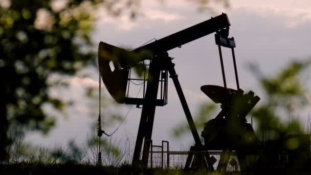 silueta pracovní olejové čerpadlo na pozadí mraků - Záběry, video