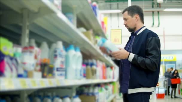 Człowiek ma zamiar kupić proszek do prania w supermarkecie - Materiał filmowy, wideo
