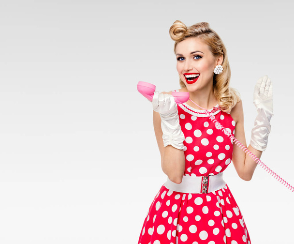smiling woman with phone, dressed in pin-up style dress - Fotó, kép