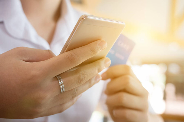 женщина держит кредитную карту и с помощью мобильного телефона для на
 - Фото, изображение
