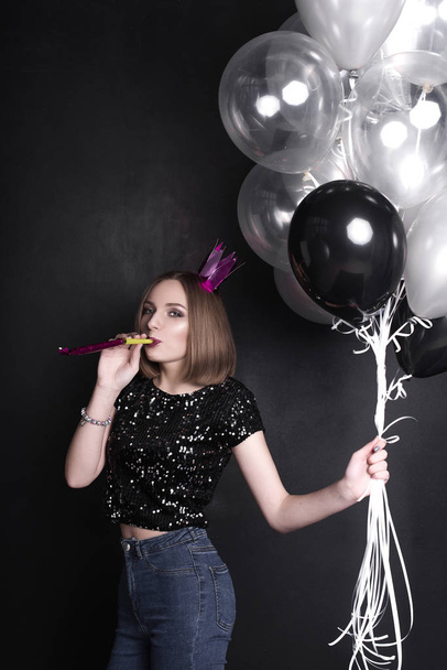 Close up fashion portrait of a young beautiful elegant girl with bright party make up in evening black sequin top. She is keeping silver stars balloons in her hand. Girl at the party. Retouched shot - Fotografie, Obrázek