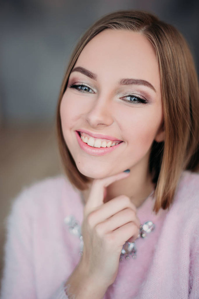 Soft photo of fresh young woman in pink tender sweater smiling. Pretty girl enjoying early sunny morning at home. - Foto, Imagem