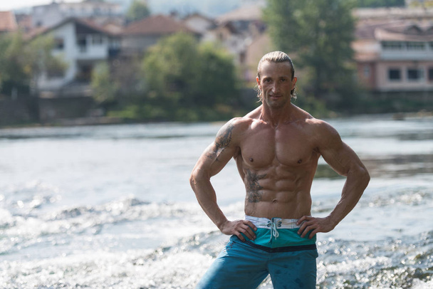Bodybuilder Flexing Muscles Outdoors In Nature - Photo, Image