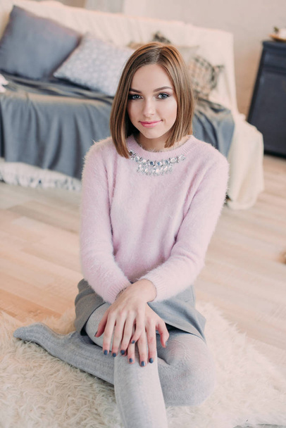 Soft photo of fresh young woman in pink tender sweater smiling. Pretty girl enjoying early sunny morning at home. - Photo, Image