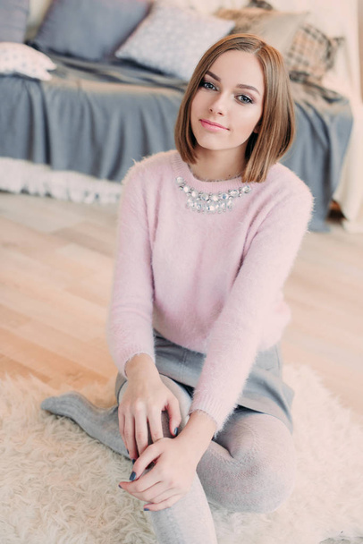 Soft photo of fresh young woman in pink tender sweater smiling. Pretty girl enjoying early sunny morning at home. - Photo, Image