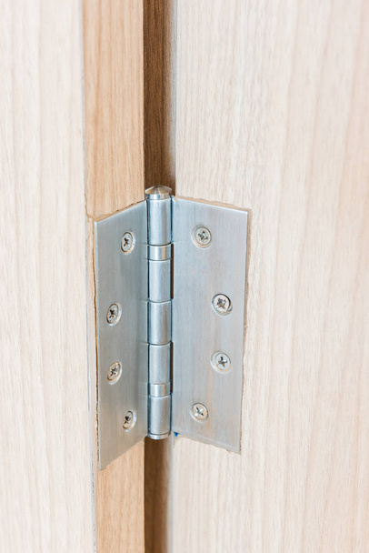Charnières de porte en acier inoxydable sur porte battante en bois  - Photo, image