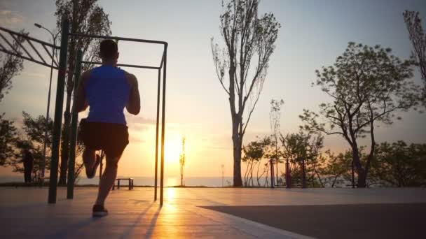 Σιλουέτα ισχυρή υγιής άνθρωπος κάνει καταλήψεις ένα πόδι προπόνηση εξωτερική αυγή αργή κίνηση - Πλάνα, βίντεο