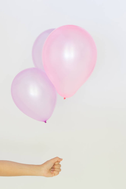 Womans hand holds balloons in a white background - Photo, Image