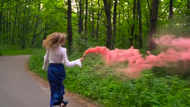 Nainen kauniissa vaatteissa kulkee metsän läpi heiluttaen värillistä savua, hidastettuna
 - Materiaali, video