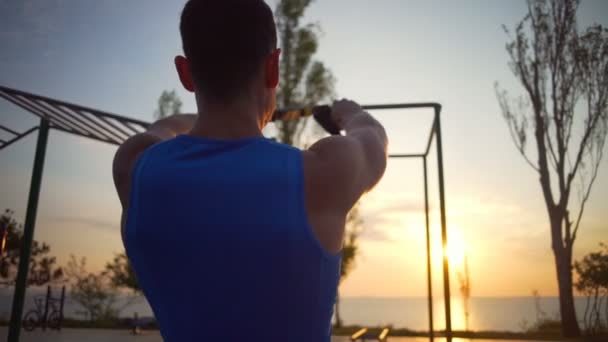 hombre comprometido en ejercicios trx tire de cambio mano entrenamiento al aire libre amanecer slow motion
 - Metraje, vídeo