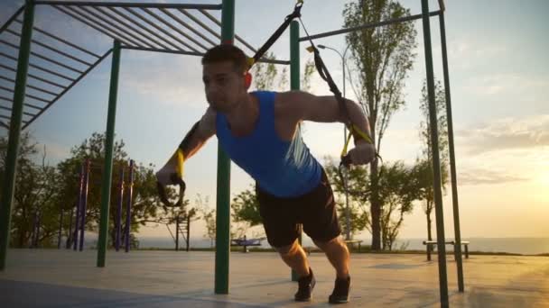 mocny człowiek zaangażowany w trx ćwiczenia podciągnąć jednej nodze zmiana treningu zwolnionym tempie - Materiał filmowy, wideo