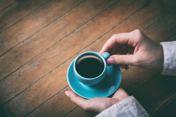 donna mani che tengono piccola tazza blu di caffè
 - Foto, immagini