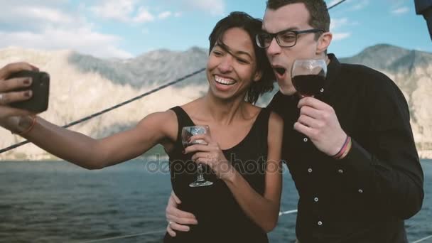 alegre pareja bebiendo vino y haciendo divertido selfie teléfono
. - Imágenes, Vídeo