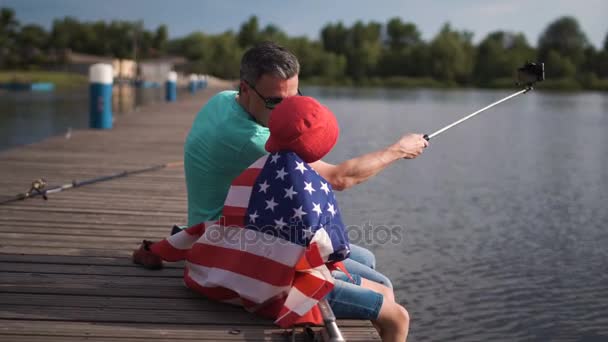 Otec a syn pózuje s americkou vlajkou - Záběry, video