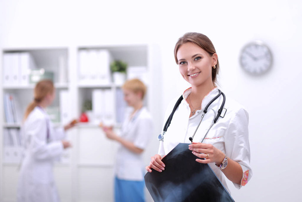Woman doctor standing at hospital with medical stethoscope - Foto, Bild