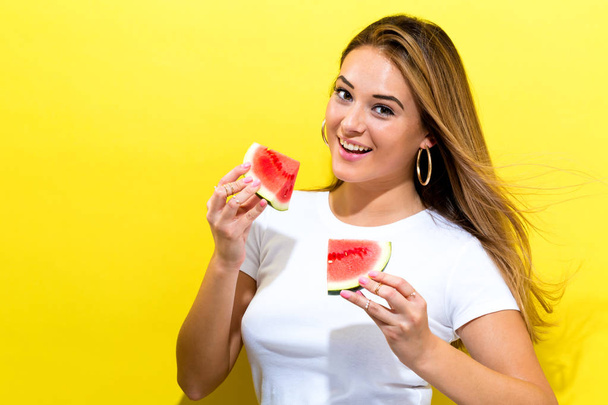 Happy young woman holding watermelon - 写真・画像