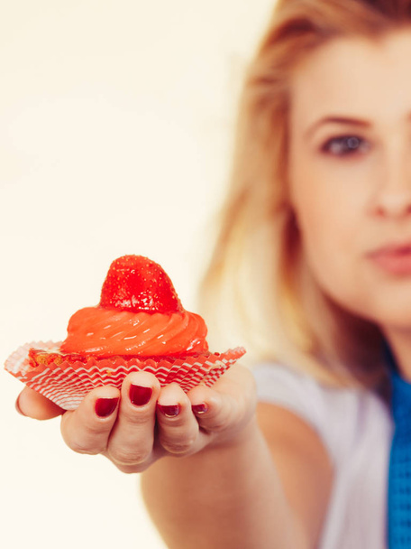 Woman with measuring tape holding sweet cupcake - 写真・画像