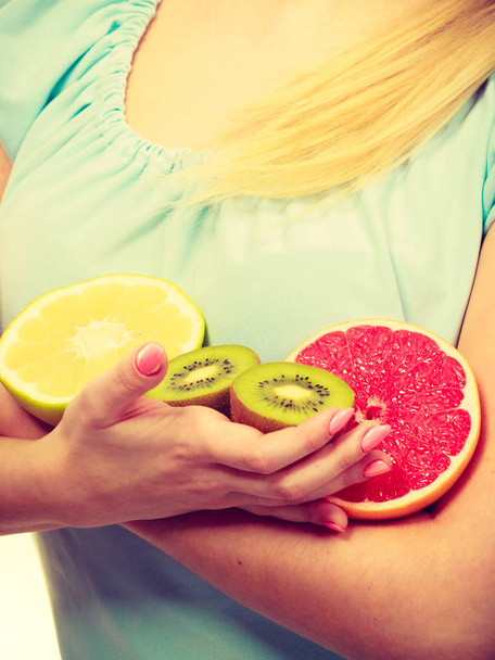 Woman holding fruits kiwi. orange, lemon and grapefruit - Foto, imagen