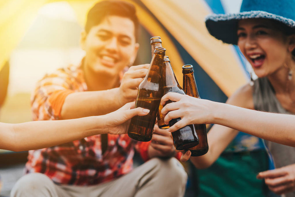 Amigos ríen y sonríen mientras brindan con cervezas
 - Foto, imagen
